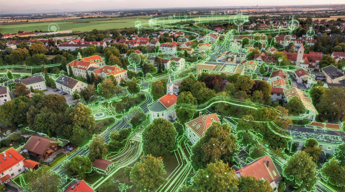 Das Bild zeigt eine Luftaufnahme der Gemeinde Feldkirchen (Foto: Winkler). Diese wurde mittels KI nachbearbeitet und um Datenflüsse innerhalb der Gemeinde ergänzt.