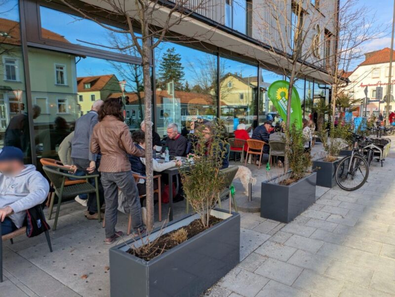 Gut besuchter Aussenbereich des Cafés Aumüller mit Interessierten der GRÜNEN in Feldkirchen und der Gemeindesratskandida:innen